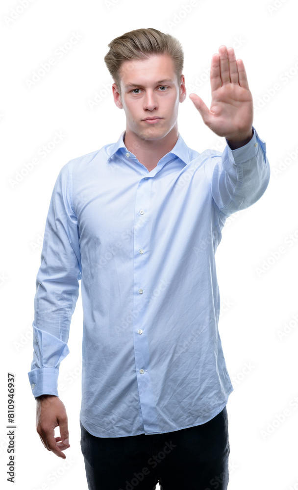 Young handsome blond man with open hand doing stop sign with serious and confident expression, defense gesture Young handsome blond man with open hand doing stop sign with serious and confident expression, defense gesture
