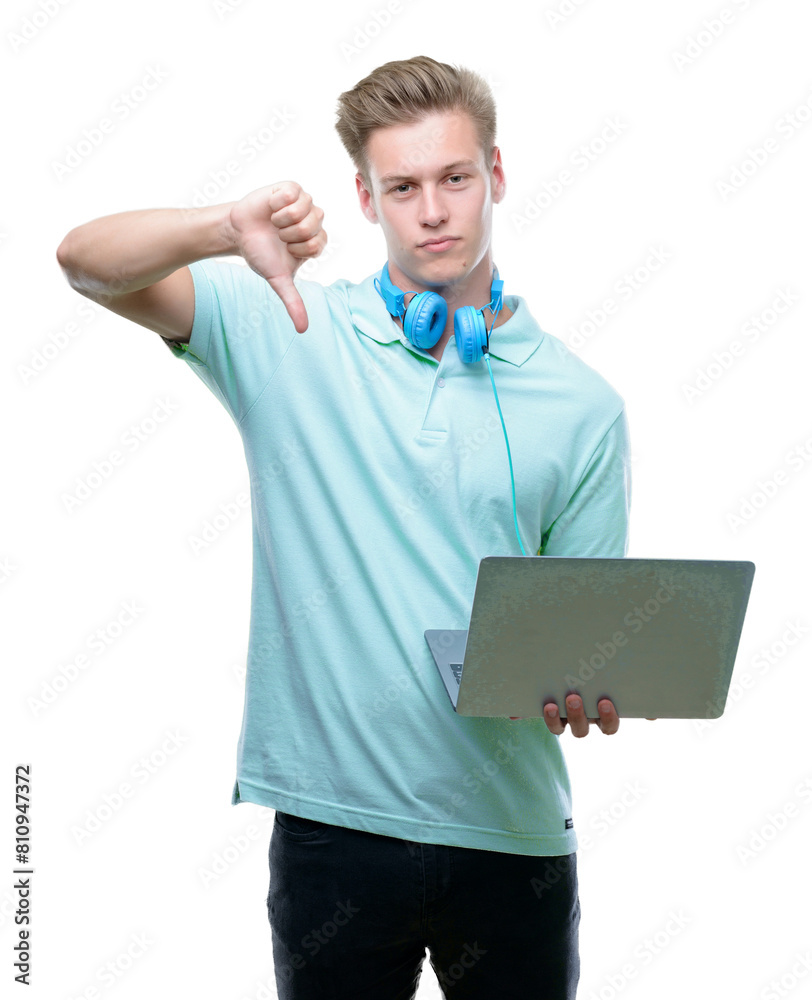 Young handsome blond man using a laptop with angry face, negative sign showing dislike with thumbs down, rejection concept Young handsome blond man using a laptop with angry face, negative sign showing dislike with thumbs down, rejection concept