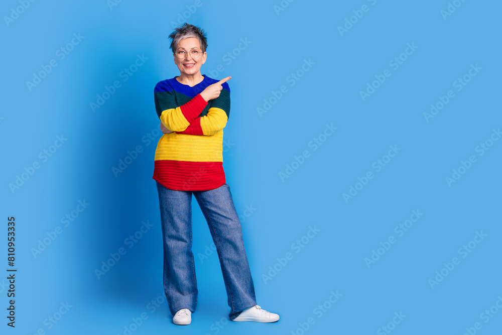 Photo of positive cheerful nice woman wear trendy striped clothes empty space isolated on blue color background Photo of positive cheerful nice woman wear trendy striped clothes empty space isolated on blue color background