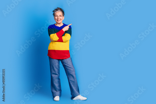 Photo of positive cheerful nice woman wear trendy striped clothes empty space isolated on blue color background