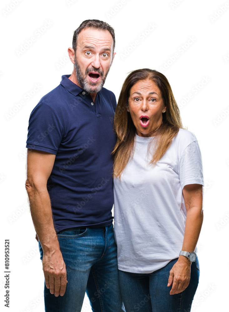 Middle age hispanic casual couple over isolated background afraid and shocked with surprise expression, fear and excited face. Middle age hispanic casual couple over isolated background afraid and shocked with surprise expression, fear and excited face.