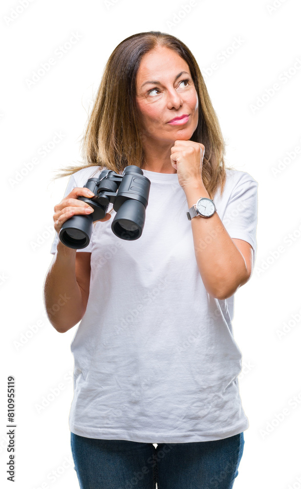 Middle age hispanic woman looking through binoculars over isolated background serious face thinking about question, very confused idea Middle age hispanic woman looking through binoculars over isolated background serious face thinking about question, very confused idea