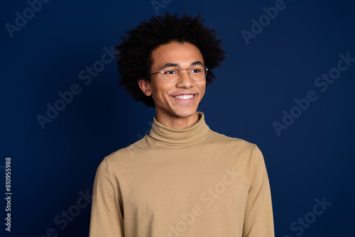 Photo portrait of nice young man look empty space smile wear trendy beige outfit isolated on dark blue color background