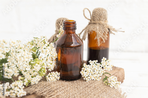 Tincture of leaves and flowers of yarrow officinalis (Achillea) in a glass bottle. Traditional medicine, the collection of useful herbs. Alternative medicine