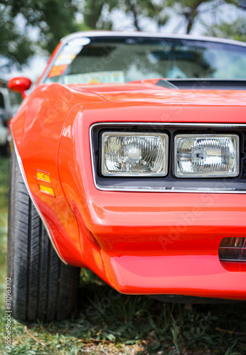 Front view of a vintage red car. Headlights. Classic vehicle. Oldtimer car.
