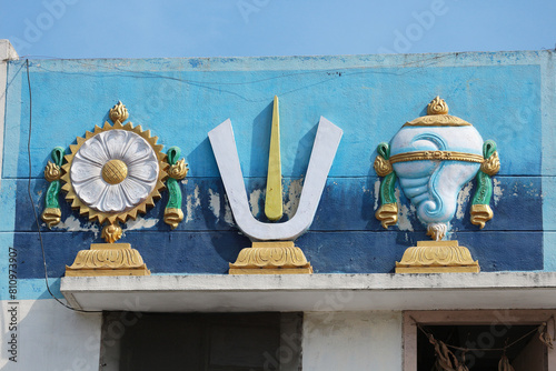 Photos Chakra disc, Vaishnava Tilak and Shankha conch - symbols attributes of God Vishnu on the wall of a Hindu temple in India