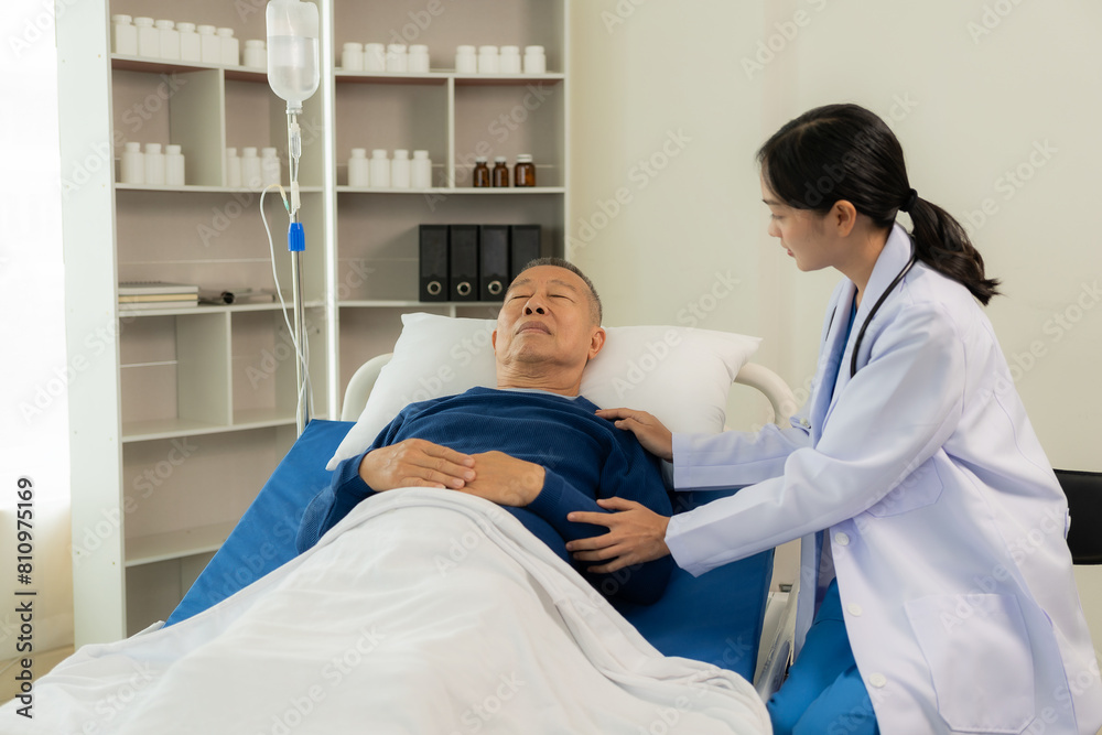Beautiful nurse doctor feels happy while talking and supporting an elderly male nursing home patient lying in bed.