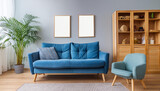 Blue sofa and armchair, wooden cabinet against wall with two frames. Scandinavian home interior design of modern living room.