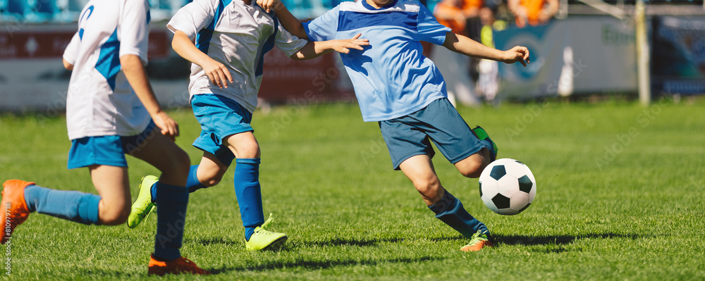 Youth soccer football league. Young boys in white and blue soccer jerseys play tournament match during youth football tournament Youth soccer football league. Young boys in white and blue soccer jerseys play tournament match during youth football tournament