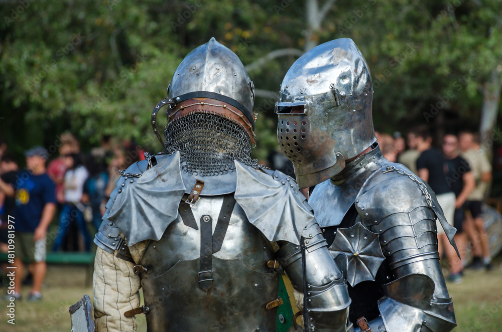 Battle of warriors tournament. Armed members of history club in knight armor demonstrating fighting skills on tournament reconstruction. Battle of warriors tournament. Armed members of history club in knight armor demonstrating fighting skills on tournament reconstruction.