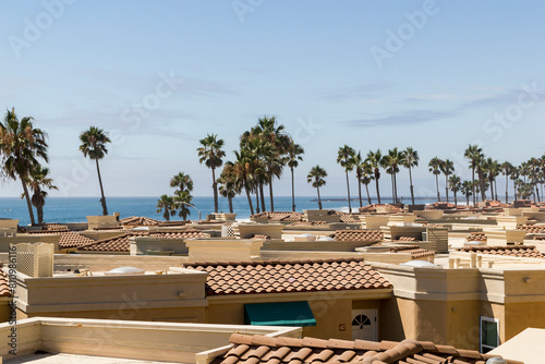 a scenic view over the beautiful coastline of oceanside with beautiful residential buildings and palm trees at a sunny day, california