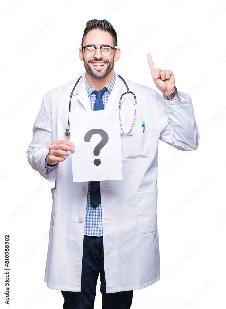Handsome young doctor man holding paper with question mark over isolated background surprised with an idea or question pointing finger with happy face, number one Handsome young doctor man holding paper with question mark over isolated background surprised with an idea or question pointing finger with happy face, number one