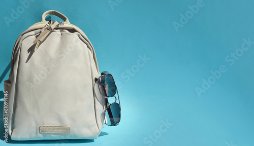 beige backpack for school, travel, bag for things. sunglasses. an element of the wardrobe. background for the design.