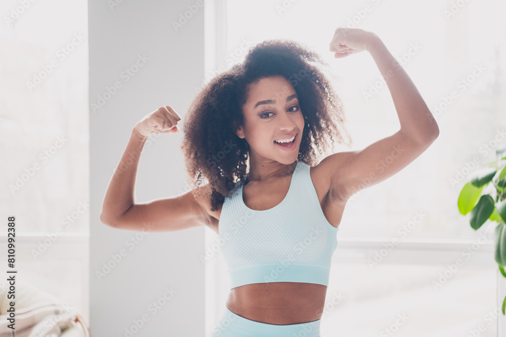 Photo of nice fit young woman hands flexing biceps sportswear training home gym indoors Photo of nice fit young woman hands flexing biceps sportswear training home gym indoors
