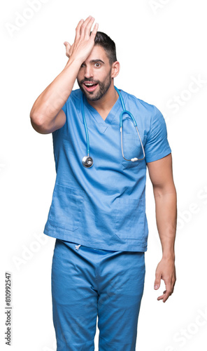Konstfotografi Handsome young doctor surgeon man over isolated background surprised with hand on head for mistake, remember error