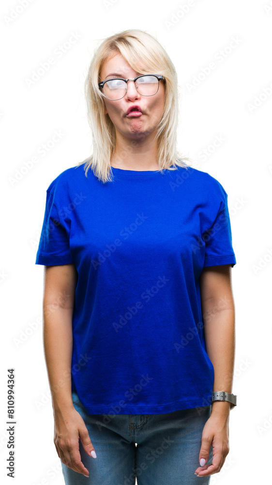 Fototapeta premium Young beautiful blonde woman wearing glasses over isolated background making fish face with lips, crazy and comical gesture. Funny expression.