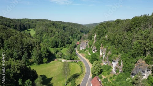 Flight through valley Trubachtal along street and panorama view of Franconian Switzerland hills, rocks and forest with trees near Obertrubach, Germany photo