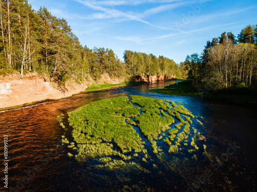 aerial view of the striking red cliffs and lush forests along a curving river Salaca in latvia photo