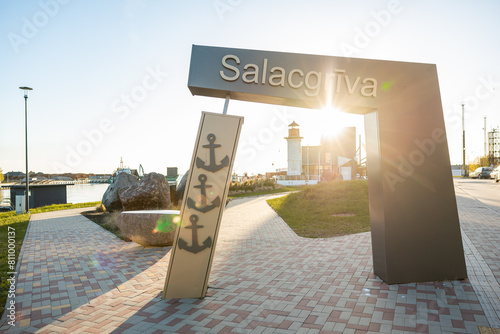 Welcoming entrance to Salacgriva in Latvia  with a decorative anchor sign and lighthouse in the background