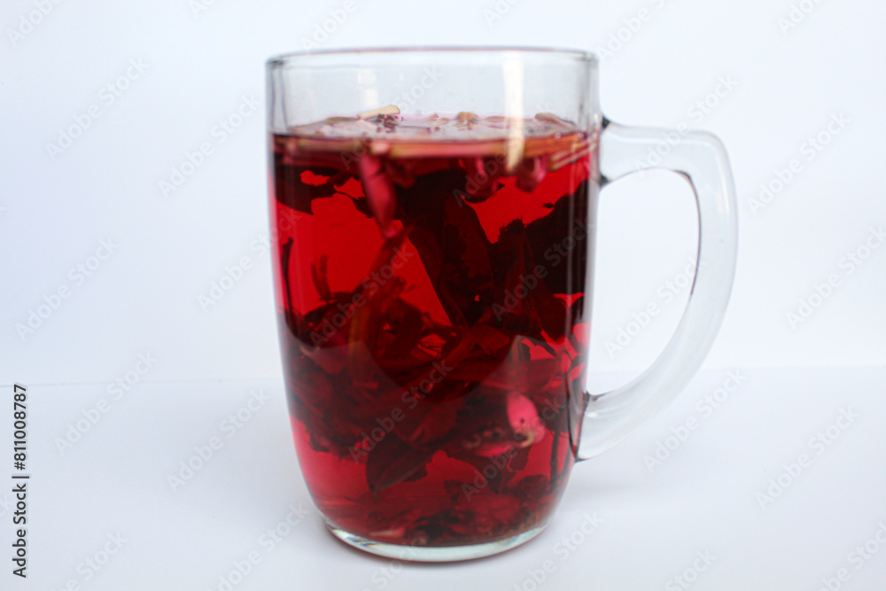 Wedang Uwuh, or traditional tea from brewed sappanwood, ginger, lemongrass and cardamom. In transparent glass, isolated on white background Wedang Uwuh, or traditional tea from brewed sappanwood, ginger, lemongrass and cardamom. In transparent glass, isolated on white background