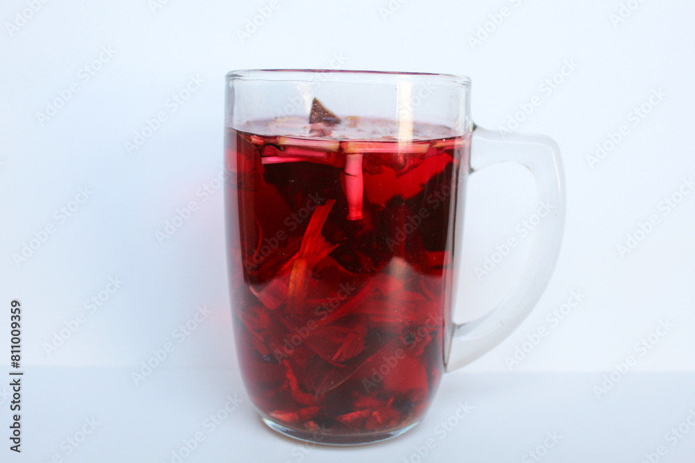 Wedang Uwuh, or traditional tea from brewed sappanwood, ginger, lemongrass and cardamom. In transparent glass, isolated on white background Wedang Uwuh, or traditional tea from brewed sappanwood, ginger, lemongrass and cardamom. In transparent glass, isolated on white background