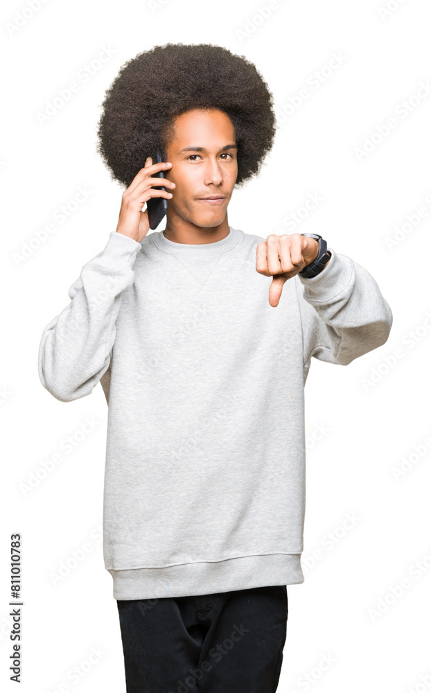 Young african american man with afro hair talking on smartphone with angry face, negative sign showing dislike with thumbs down, rejection concept Young african american man with afro hair talking on smartphone with angry face, negative sign showing dislike with thumbs down, rejection concept