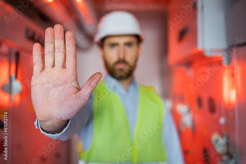 Male Engineer palm Disapproving With No Hand Sign While Standing In The red lighted room