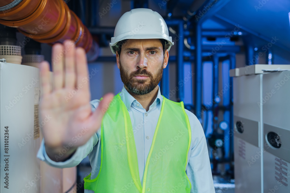 workman wearing safety vest and helmet making stop gesture with his hand denying a situation that could wrong. workman wearing safety vest and helmet making stop gesture with his hand denying a situation that could wrong.