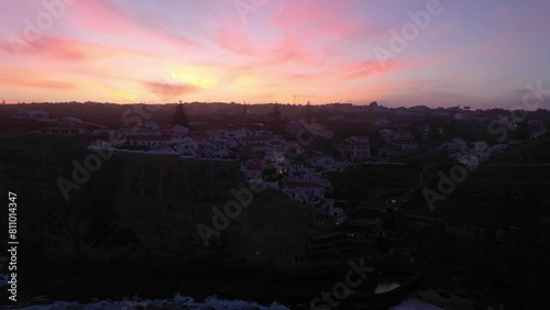 Azenhas do Mar Village in Portugal at Morning Twilight, Cliffs and Waves of Atlantic Ocean. Aerial View. Orbiting. Pink Sky photo