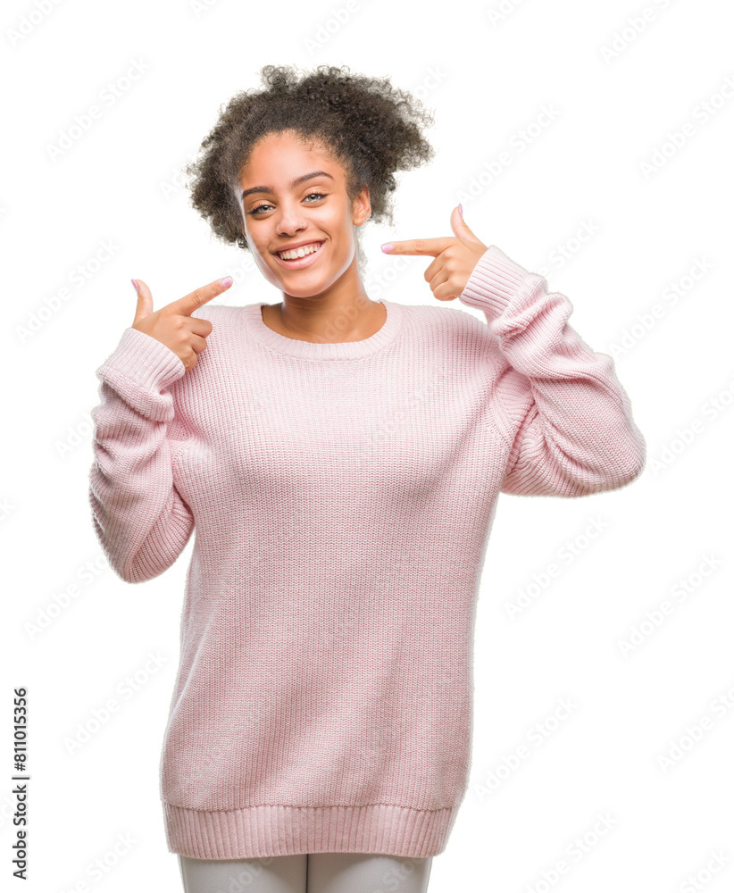 Young afro american woman wearing winter sweater over isolated background smiling confident showing and pointing with fingers teeth and mouth. Health concept. Young afro american woman wearing winter sweater over isolated background smiling confident showing and pointing with fingers teeth and mouth. Health concept.