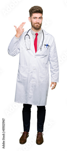 Young handsome doctor man wearing medical coat Shooting and killing oneself pointing hand and fingers to head, suicide gesture.