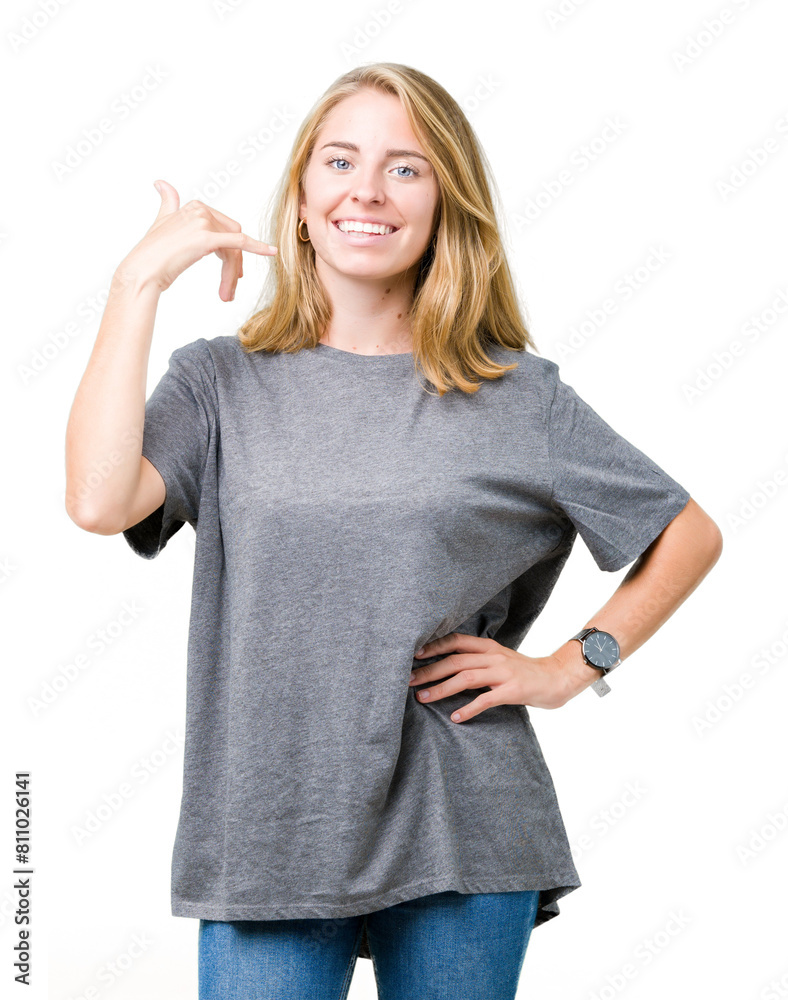 Beautiful young woman wearing oversize casual t-shirt over isolated background smiling doing phone gesture with hand and fingers like talking on the telephone. Communicating concepts. Beautiful young woman wearing oversize casual t-shirt over isolated background smiling doing phone gesture with hand and fingers like talking on the telephone. Communicating concepts.
