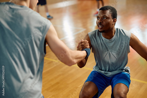 Canvastavla Basketball player assisting his teammate in getting up after  foul during sports match