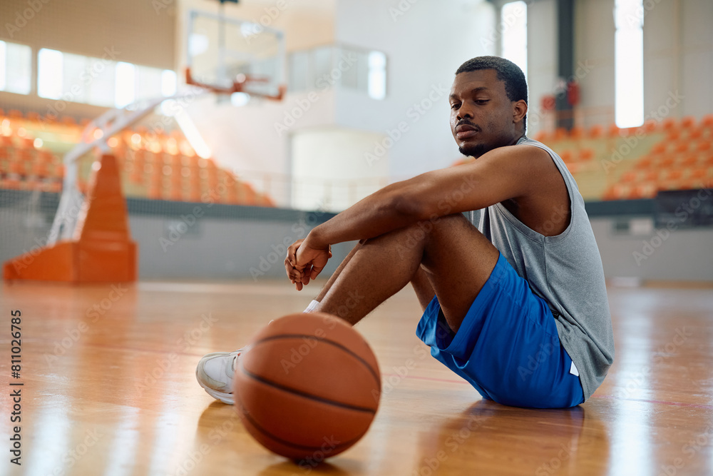 Black basketball player relaxing on court. Black basketball player relaxing on court.