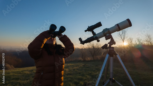Amateur astronomer observing skies with binoculars and telescope