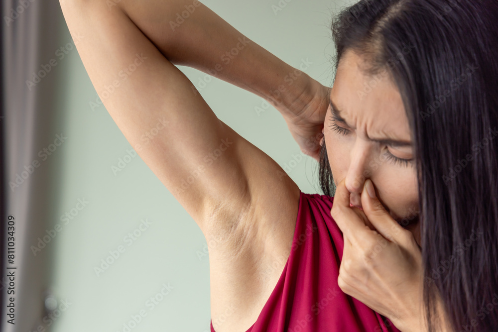 Young Asian woman sweating, feeling bad and uncomfortable with stinking smelly odor or bad musty smell during summer day with high temperature or heat wave, healthcare and body care concept image Young Asian woman sweating, feeling bad and uncomfortable with stinking smelly odor or bad musty smell during summer day with high temperature or heat wave, healthcare and body care concept image