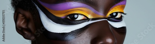 A Black individual with a non binary flag inspired makeup, featuring a striking combination of yellow, white, purple, and black around the eyes photo