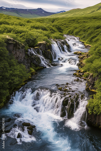 a scenic waterfall  lush greenery  rocky terrain  distant mountains  and a clear sky