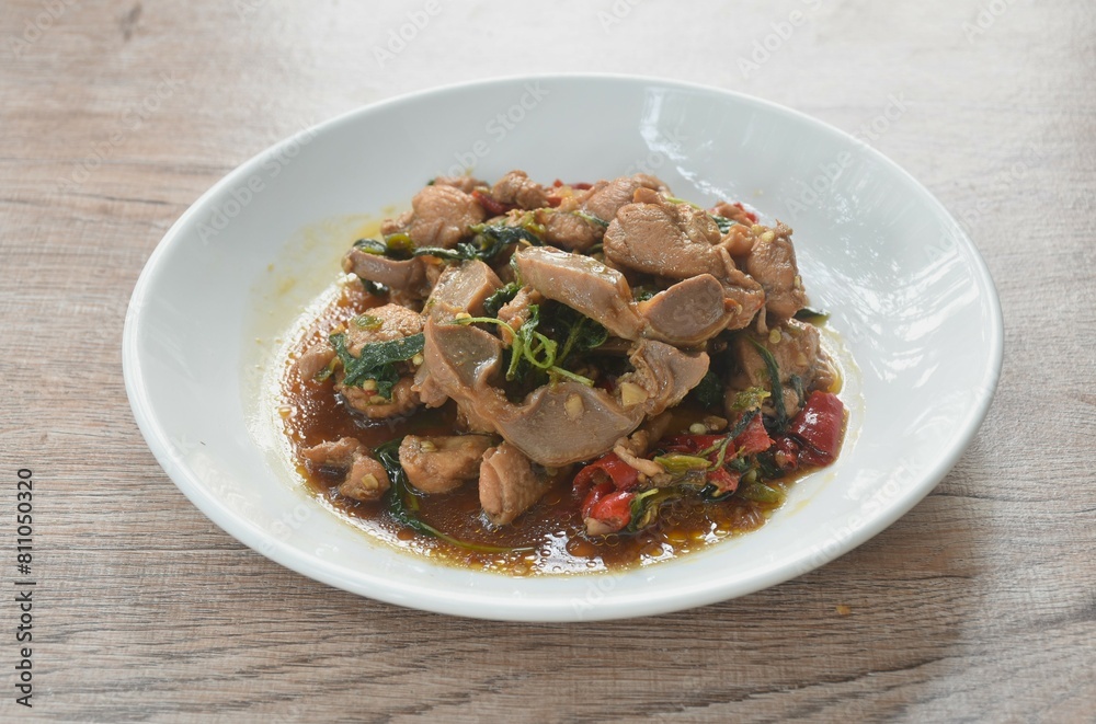 spicy chili stir-fried chicken meat and gizzard couple liver with basil leaf on plate spicy chili stir-fried chicken meat and gizzard couple liver with basil leaf on plate