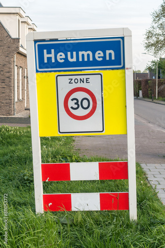 Place name sign for the village of Heumen (also speed limit of 30 km per hour) photo