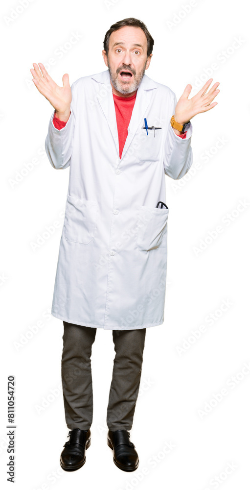 Middle age therapist wearing white coat clueless and confused expression with arms and hands raised. Doubt concept. Middle age therapist wearing white coat clueless and confused expression with arms and hands raised. Doubt concept.