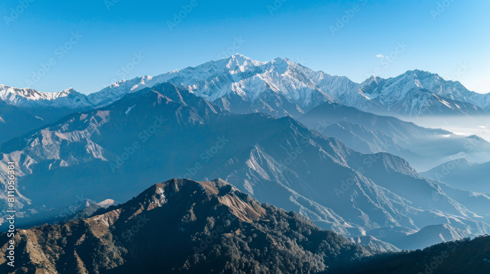 Obraz premium high-altitude drone photograph of snow-capped mountains under clear blue skies