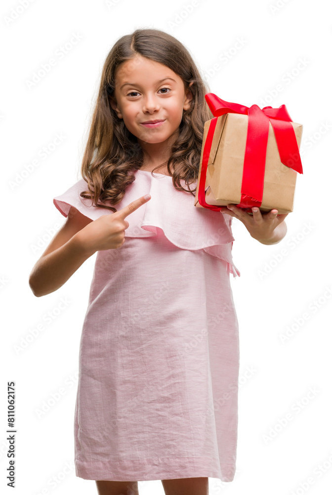 Brunette hispanic girl holding a gift very happy pointing with hand and finger Brunette hispanic girl holding a gift very happy pointing with hand and finger