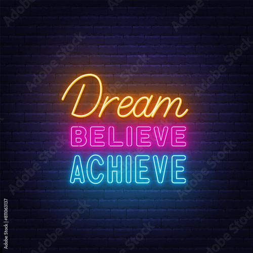 Dream Believe Achieve  neon lettering on brick wall background