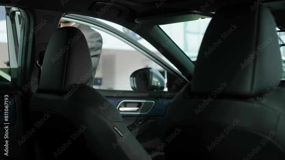 The buyer, a client of a modern car dealership, chooses a car. A dealer talks about a new model of a modern electric car. The concept of test drive, buying an electric car or renting it. The buyer, a client of a modern car dealership, chooses a car. A dealer talks about a new model of a modern electric car. The concept of test drive, buying an electric car or renting it.