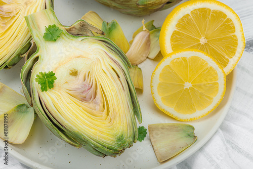 Fresh green artichokes cooking on wooden background. Traditional seasonal ingredients photo