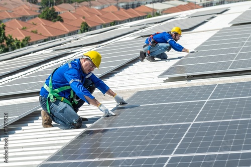 Two solar panel workers installing solar panels on a roof