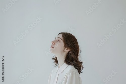 Serene profile of a woman against a clean white background, showcasing a look of calm and tranquility, ideal for health and wellness themes.   © Kishore Newton