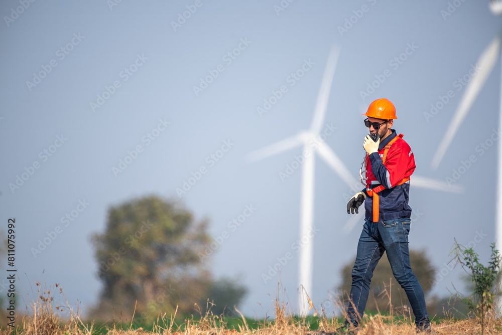 Male man engineer inspection posing check control wind power machine in out door wind energy factory. Young man technician professional worker check wind power machine for maintenance turbine