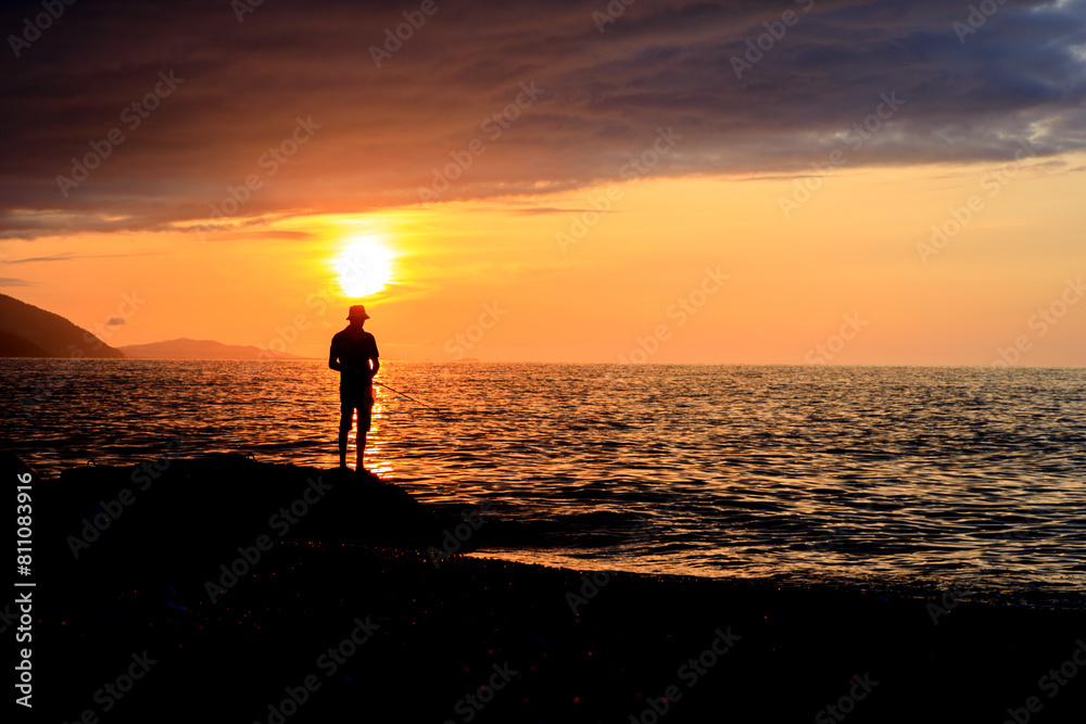 Fototapeta premium A person is standing on a beach at sunset